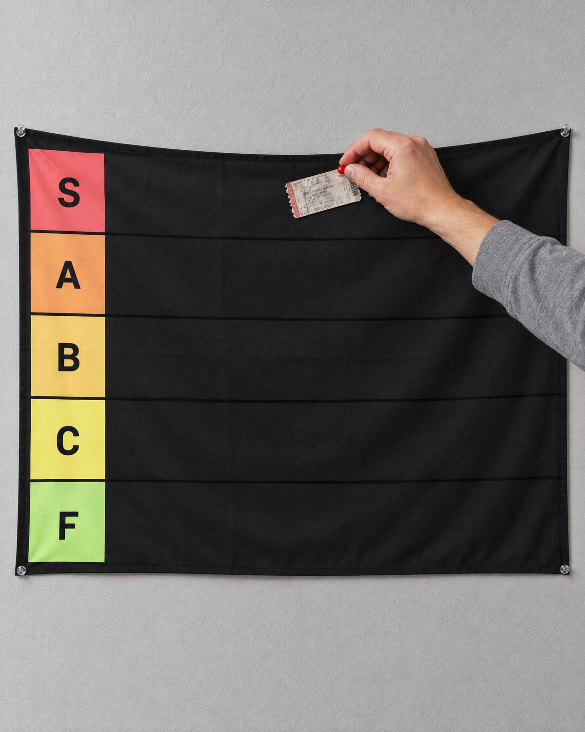 A hand pinning a ticket into the S tier row