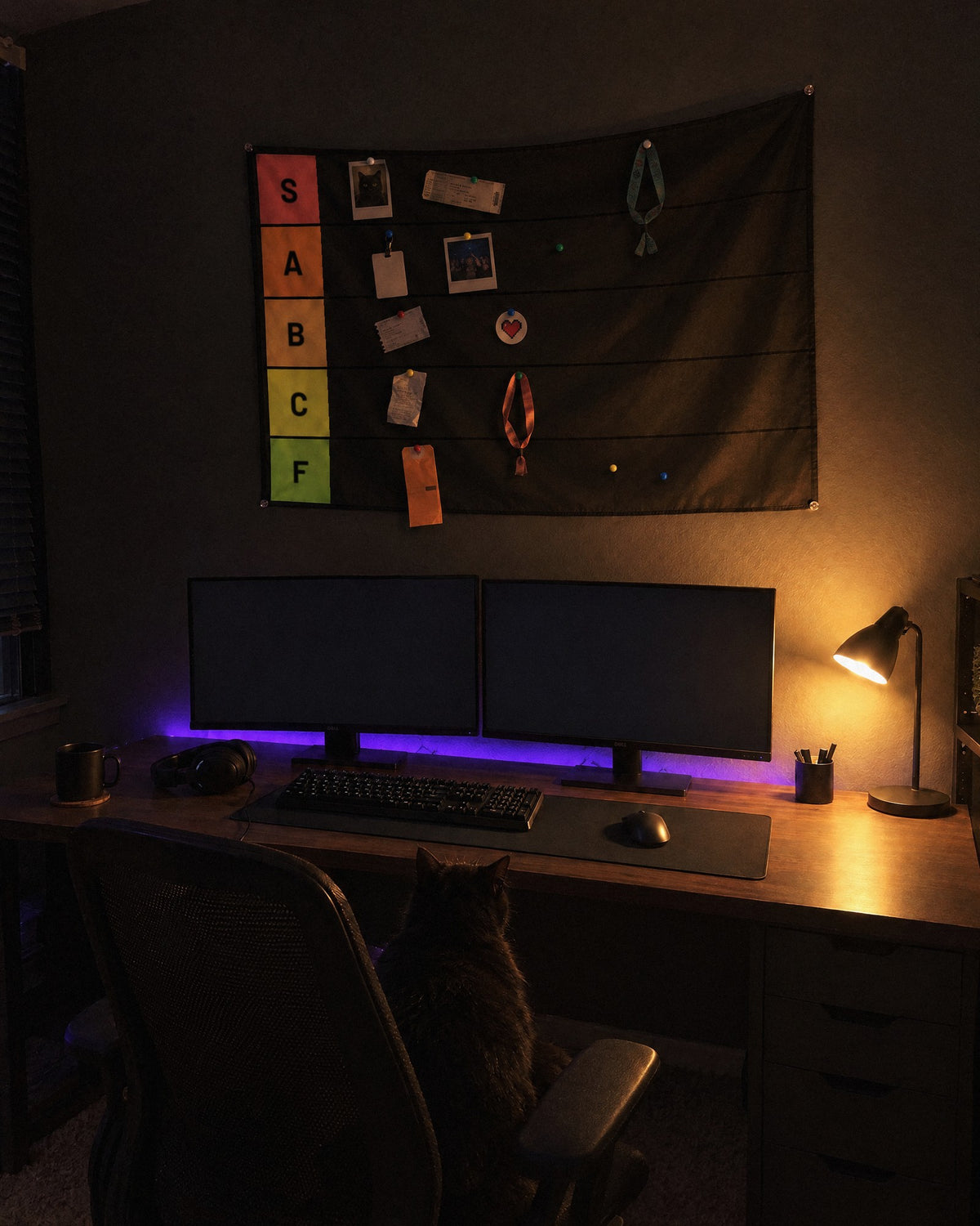 Tier list tapestry over a gaming desk at night