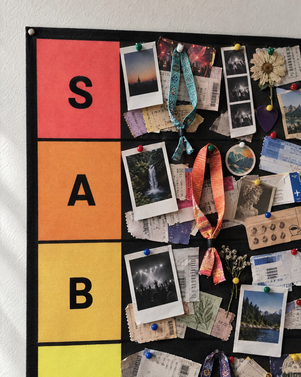 Close up of a packed S, A and B tier: instant photos, concert tickets, festival wristbands and postcards pinned across the rows