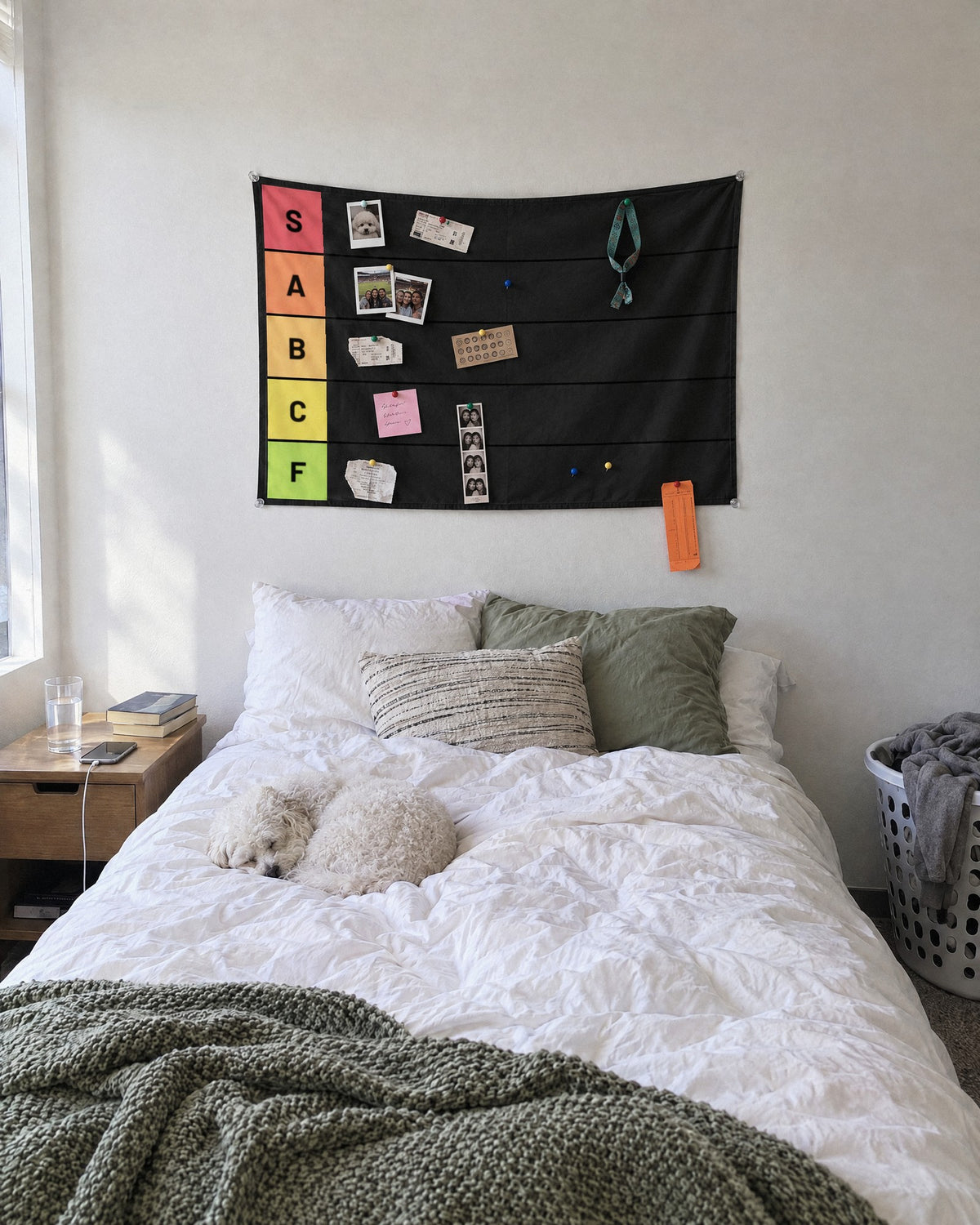 Tier list wall tapestry hung in a bright bedroom with photos, tickets and a dog photo pinned in S tier