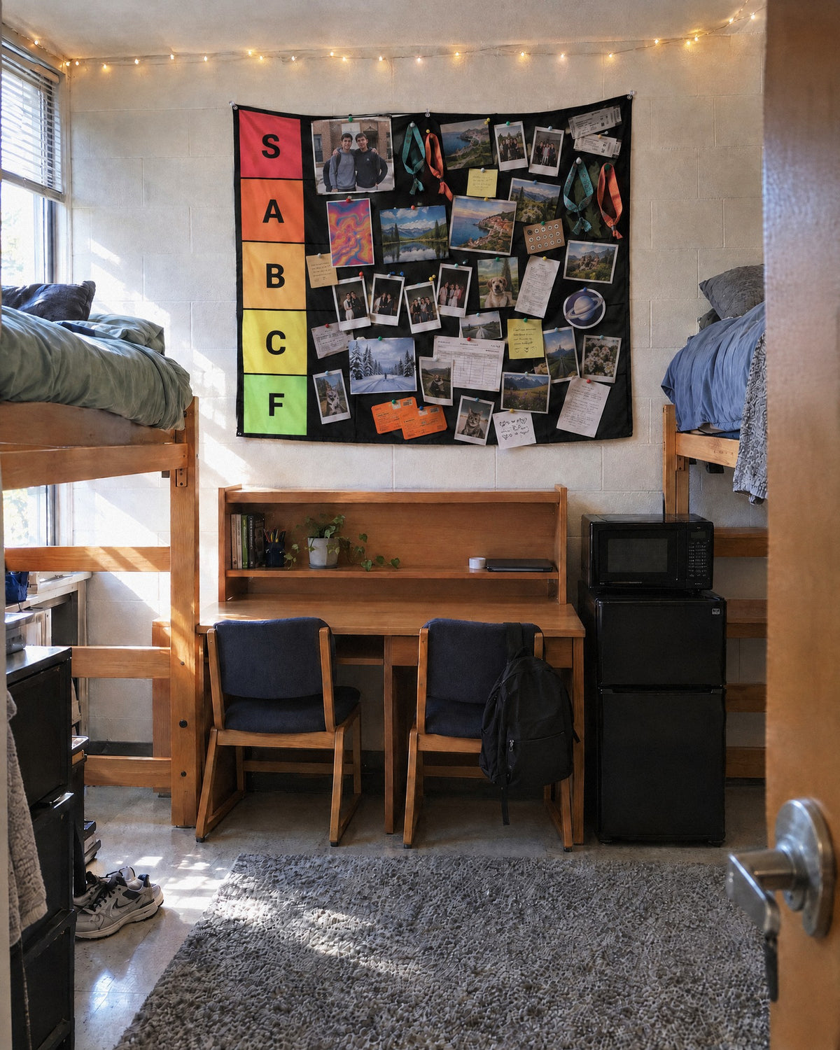 XL tier list tapestry above a shared desk in a college dorm, packed with photos and tickets